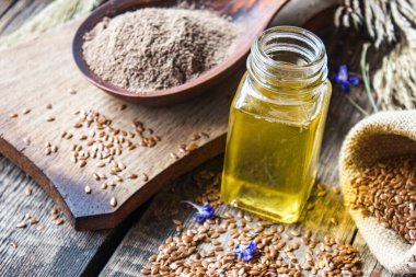 Keten tohumu yağı şişede, kaşık içinde doğranmış keten tohumlarının yanında. Keten tohumu yağı yemek, ilaç ve kozmetolojide kullanılır..