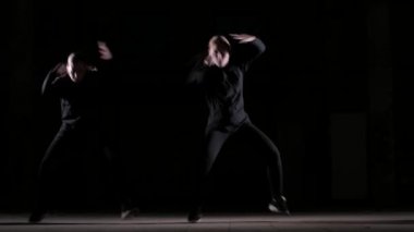 Dans eden genç ve güzel kadınların düeti hip hop, stüdyoda siyah bir arka planda sokak dansı, izole edilmiş