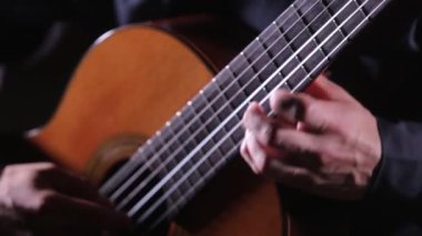 Gitar tellerinin ve fretboard 'un yakın çekimi, akustik gitar çalan gitarist