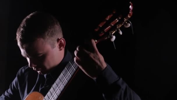 Joven Guapo Magistralmente Toca Guitarra Acústica Clásica Sobre Fondo Negro — Vídeos de Stock