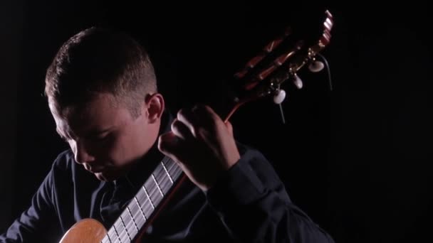 Przystojny Młody Mężczyzna Mistrzowsko Gra Klasycznej Gitarze Akustycznej Czarnym Tle — Wideo stockowe