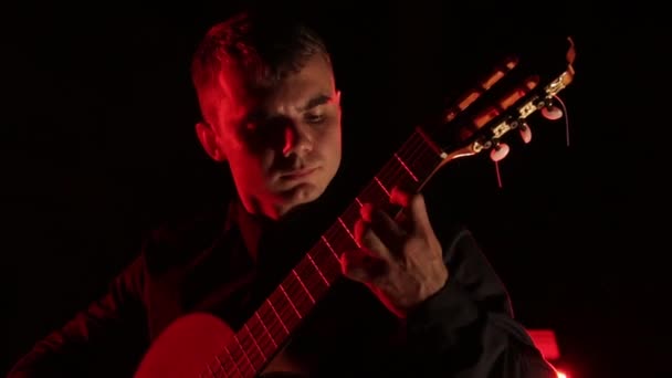 남자는 열정적으로 배경에서 어쿠스틱 기타를 얼굴을 클로즈업하고 고립된 — 비디오