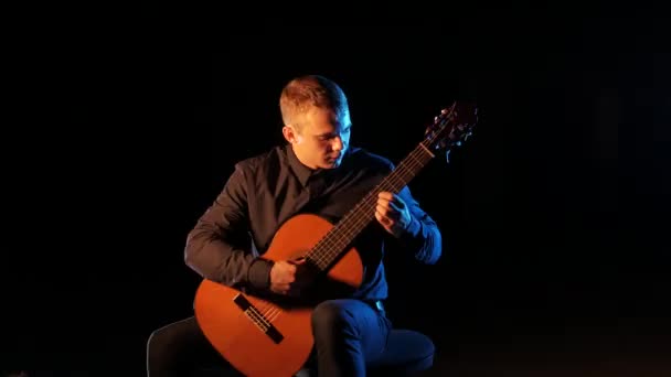 Guitarrista Toca Música Clásica Una Guitarra Acústica Sobre Fondo Negro — Vídeo de stock