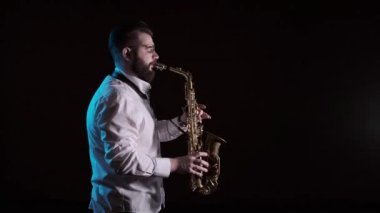 Saksafon çalan yakışıklı adam, siyah arkaplan, soyutlanmış, tek başına.