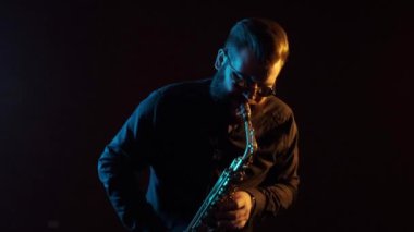 Saksafonda çalan aktörün solo konseri, siyah arka plan, izole edilmiş.