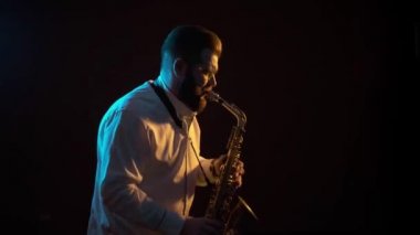 Saksafoncu saksafon çalar, siyah arkaplan, soyutlanmış, tek başına