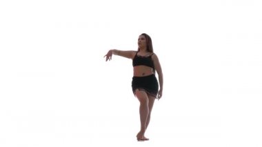 Uzun saçlı güzel bir kız ve siyah bluzlu ve kısa etekli güzel tombul bir kadın göbek dansı, doğulu dans, beyaz arka planda egzotik dans, izole edilmiş, yavaş çekim.