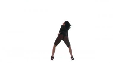 Siyah şeffaf dar takım elbiseli güzel bir kızın silueti enerjik bir şekilde dans salonu, sokak dansı, beyaz arka planda twerk, izole edilmiş, yavaş çekim