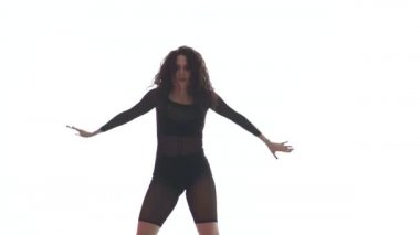 Siyah şeffaf dar takım elbiseli güzel bir kadının uzun pozu enerjik bir şekilde dans salonu, sokak dansı, beyaz arka planda twerk, izole edilmiş.