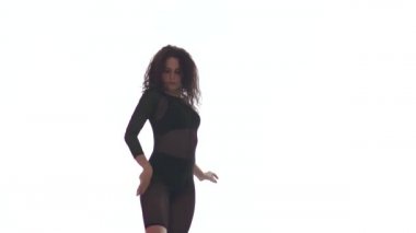 Siyah şeffaf dar takım elbiseli güzel bir kadının uzun pozu enerjik bir şekilde dans salonu, sokak dansı, beyaz arka planda twerk, izole edilmiş.