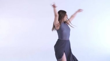 Uzun saçlı, uzun saçlı, modern bale dansı, yavaş çekim, izole edilmiş genç ve güzel bir kadın dansçının orta boy uzun pozu.