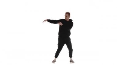 Siyah eşofmanlı genç yakışıklı adam güçlü bir şekilde dans ediyor hip hop, serbest stil, sokak dansı, karmaşık hareketler yapıyor, izole edilmiş.