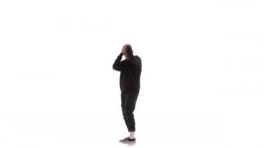 Siyah eşofmanlı genç yakışıklı adam güçlü bir şekilde dans ediyor hip hop, serbest stil, sokak dansı, karmaşık hareketler yapıyor, izole edilmiş.