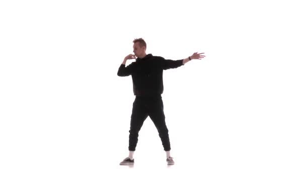 ブラックトラックスーツの若いハンサムな男が精力的にヒップホップ フリースタイル ストリートダンスを踊り 複雑な動きを実行し 隔離された — ストック動画