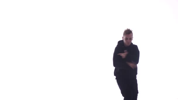中長いショットの若いハンサムな男で黒のトラックスーツ精力的にダンスヒップホップ フリースタイル ストリートダンス — ストック動画
