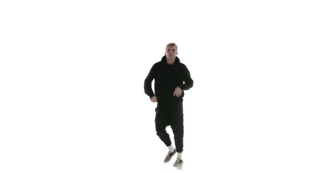 jeune beau mec en survêtement noir dansant vigoureusement hip hop, freestyle, street dance, effectue des mouvements complexes, isolé, slow motion 
