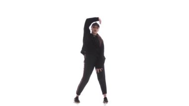 Eşofmanlı, beysbol şapkalı hiphop dansı yapan, modern sokak dansı yapan, izole edilmiş genç ve güzel bir kız dansçı.