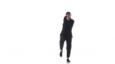Eşofmanlı, beysbol şapkalı hiphop dansı yapan, modern sokak dansı yapan, izole edilmiş genç ve güzel bir kız dansçı.