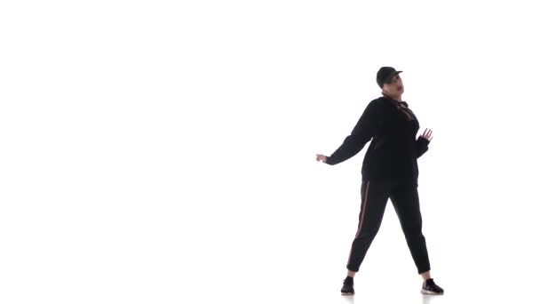 jeune belle fille danseuse en survêtement et casquette de baseball dansant hiphop, contemporain, danse de rue moderne, isolé 