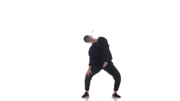 jeune belle fille danseuse en survêtement et casquette de baseball dansant hiphop, contemporain, danse de rue moderne, isolé 