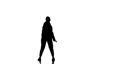 Beyaz arka planda siyah bir siluet eşofman ve beysbol şapkalı genç bir kız dansçı hip hop, çağdaş, modern sokak dansı, yavaş çekim