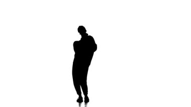 Beyaz arka planda siyah bir siluet eşofman ve beysbol şapkalı genç bir kız dansçı hip hop, çağdaş, modern sokak dansı, yavaş çekim