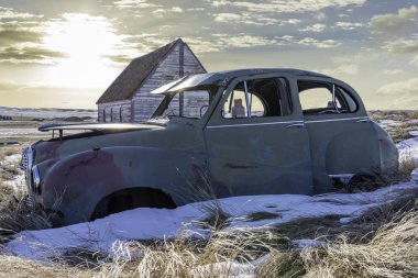 Neidpath, SK 'deki ikiz tahıl asansörlerine bakan karlı bir yamaçta terk edilmiş araba ve kilise.