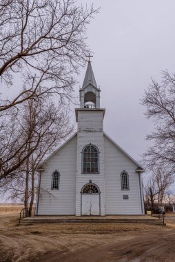 Coderre, Saskatchewan, Kanada 'da ağaçlarla çevrili klasik St. Charles Katolik Kilisesi.