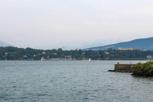 La femme est assise sur la jetée du lac Léman . — Photo