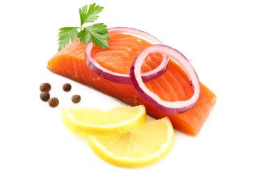 Kırmızı balık. Maydanozlu çiğ somon filetosu, biber, soğan dilimleri ve beyaz arka planda limon izolasyonu..