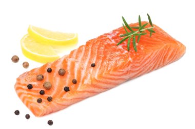 Kırmızı balık. Biberiye ve limonlu çiğ somon filetosu beyaz arka planda izole edilir..