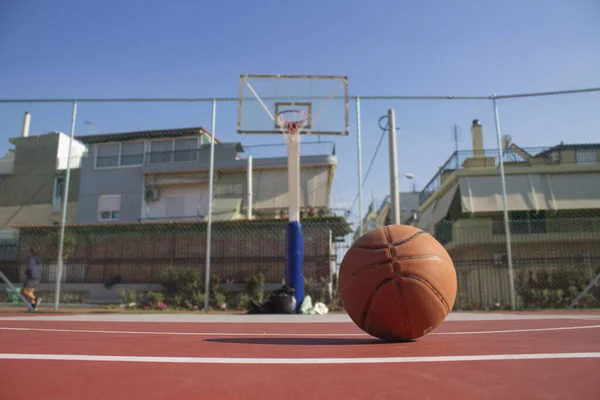 Використана баскетбол на передньому плані лежить на баскетбольному майданчику і баскетбольний баскетбол з розмитим тлом — стокове фото