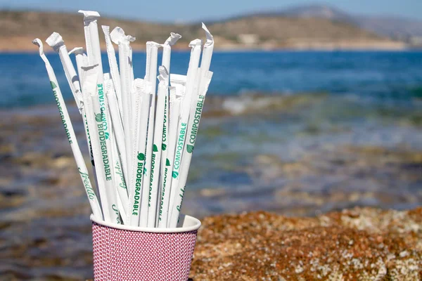 Grèce. Athènes. 13.05.2020. Pailles à boire en papier dans une tasse de papier à l'extérieur sur des rochers à côté de la mer Images De Stock Libres De Droits