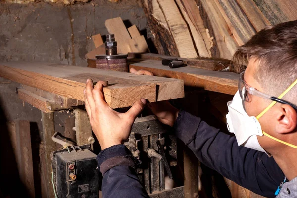 Wood worker selects flat boards for the manufacture of wood products,carpenter artisan checks the quality of wooden workpieces — Stock Photo, Image