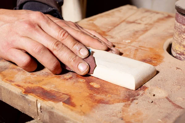 Шлифовка деревянной заготовки с наждачной бумагой, деревообработка полирует деревянные детали — стоковое фото