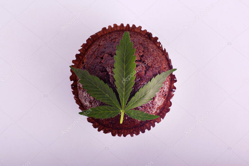 chocolate muffin and green marijuana leaf. recreational drug cannabis cake