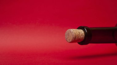 Kırmızı arka planda boş şarap şişesi ve mantar. Alkol romantik içki konsepti