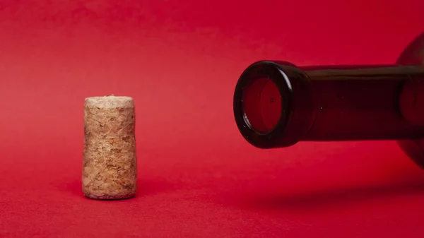 empty wine bottle and cork on red background. alcohol  romantic drink concept