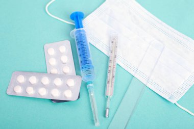 Anti-virüs tıbbi malzemeleri. Ölümcül koronavirüs salgını kavramı. Termometre, maske, aşılı şırınga ve antibiyotik hapları. kavram: Solunum hastalığı