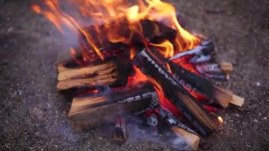 Yakılmış odun yakmak, kamp ateşi yakmak.