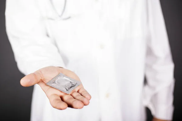 Doktor güvenli seks için prezervatif öneriyor. Cinsel yolla bulaşan hastalıklara karşı koruma — Stok fotoğraf