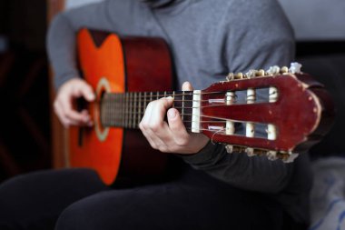 Naylon telli altı telli akustik gitar çalan bir kız.