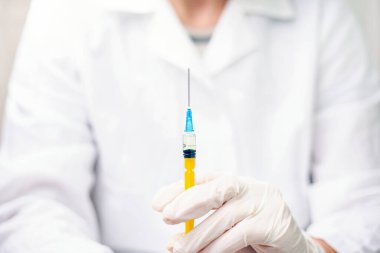 Doktor elinde ilaçlı bir şırınga tutuyor. Konsept: Grip aşısı, koronavirüs, hepatit, AIDS