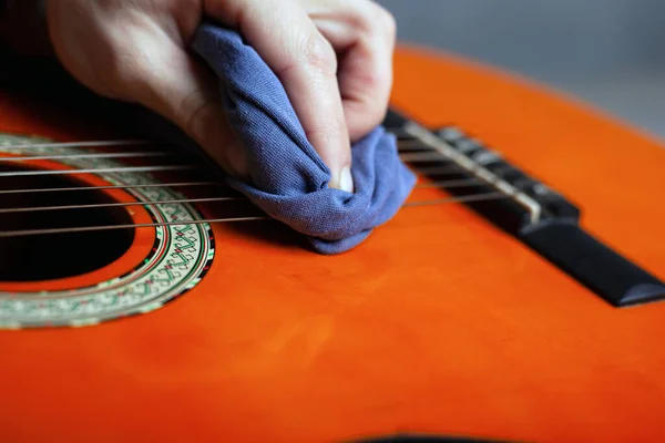 cleaning the acoustic guitar body with a clean rag