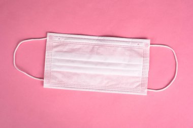 Pembe arka planda tıbbi gazlı bez koruyucu maske.