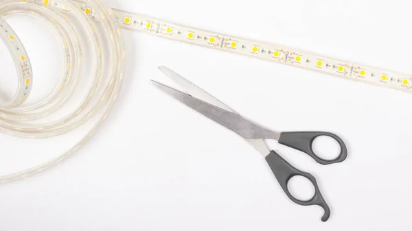 LED tape and scissors on a white background top view. — Stock Photo, Image