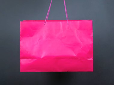 Gri arka planda büyük, pembe bir paket. Alışveriş hediyesi. indirimler