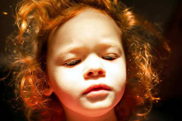 Рыжая маленькая девочка с кукольным лицом с твердым солнечным светом и светящимися волосами. милый сказочный ребенок — стоковое фото