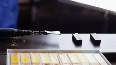 Lehimlendirici demir ve siyah ahşap kapıdaki balmumu kalemler. Restorasyon aletleri, çiziklerin onarımı, ahşap bir yüzeydeki kusurlar.