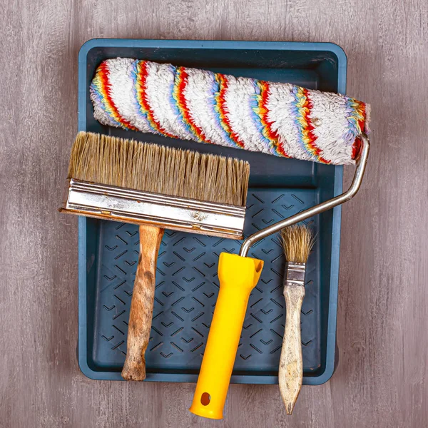 Painting tools. brushes for painting walls and ceilings roller in tray on a gray background top view — Stock Photo, Image